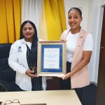 Dos representantes de CEMADOJA sostienen un reconocimiento institucional