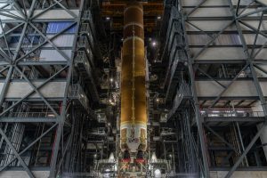 Etapa central anaranjada del cohete SLS de Artemis III, suspendida en posición vertical dentro del Edificio de Ensamblaje de Vehículos del Centro Espacial Kennedy.