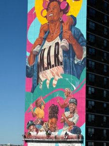 Detalle del mural con una mujer en rolos y una niña sobre sus hombros.