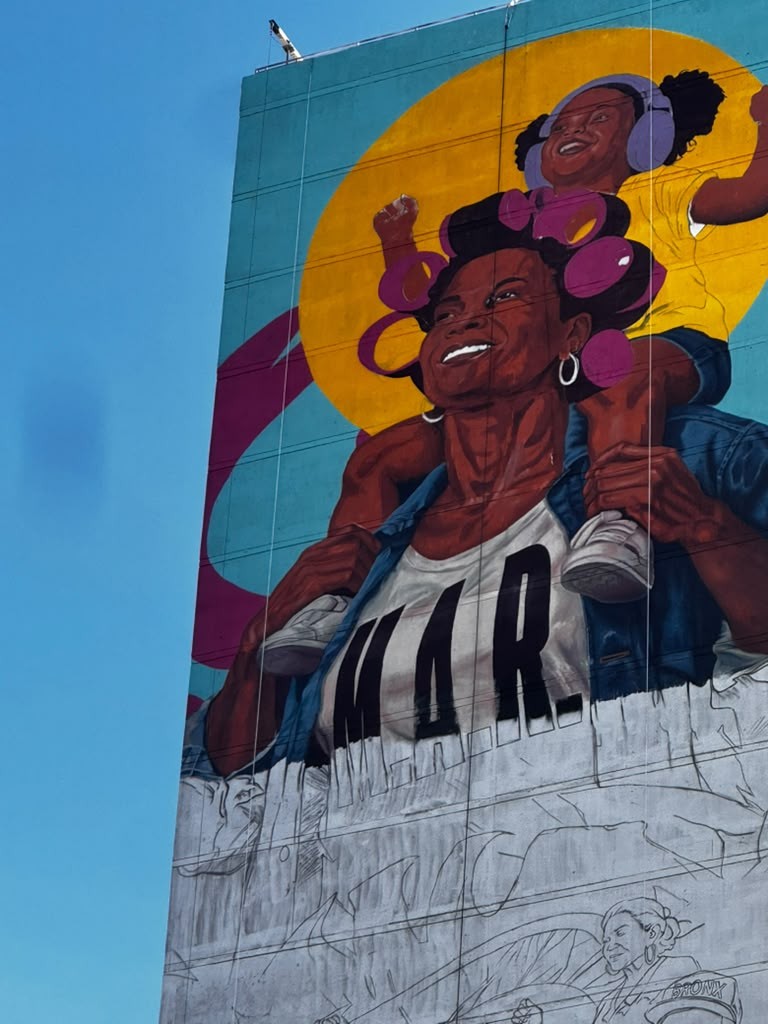 Detalle de la parte superior del mural mientras continúa el trabajo en la fachada.