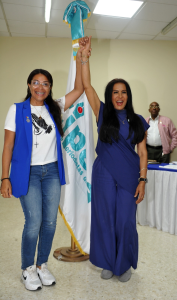 Dos participantes levantan sus manos durante la jornada electoral de CIPESA