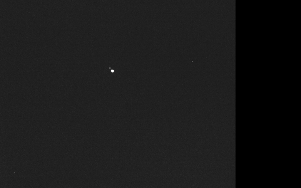 Imagen monocromática captada por la nave Hera en la que aparecen dos puntos luminosos separados correspondientes a los asteroides Didymos y Dimorphos.