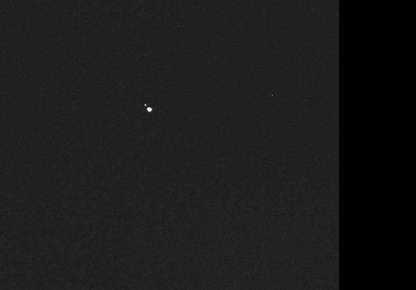 Imagen monocromática captada por la nave Hera en la que aparecen dos puntos luminosos separados correspondientes a los asteroides Didymos y Dimorphos.