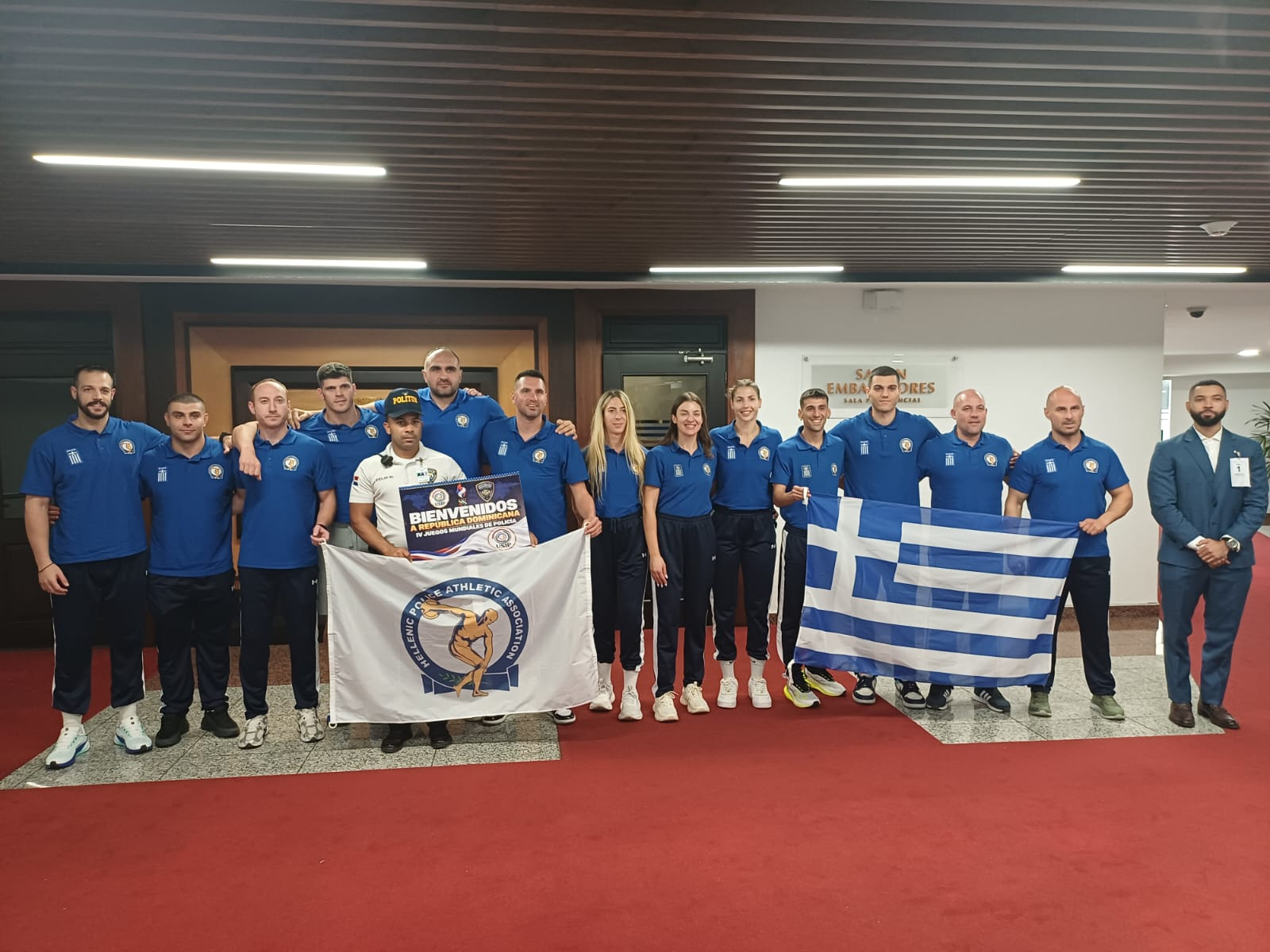 Delegación junto a una bandera de Grecia.