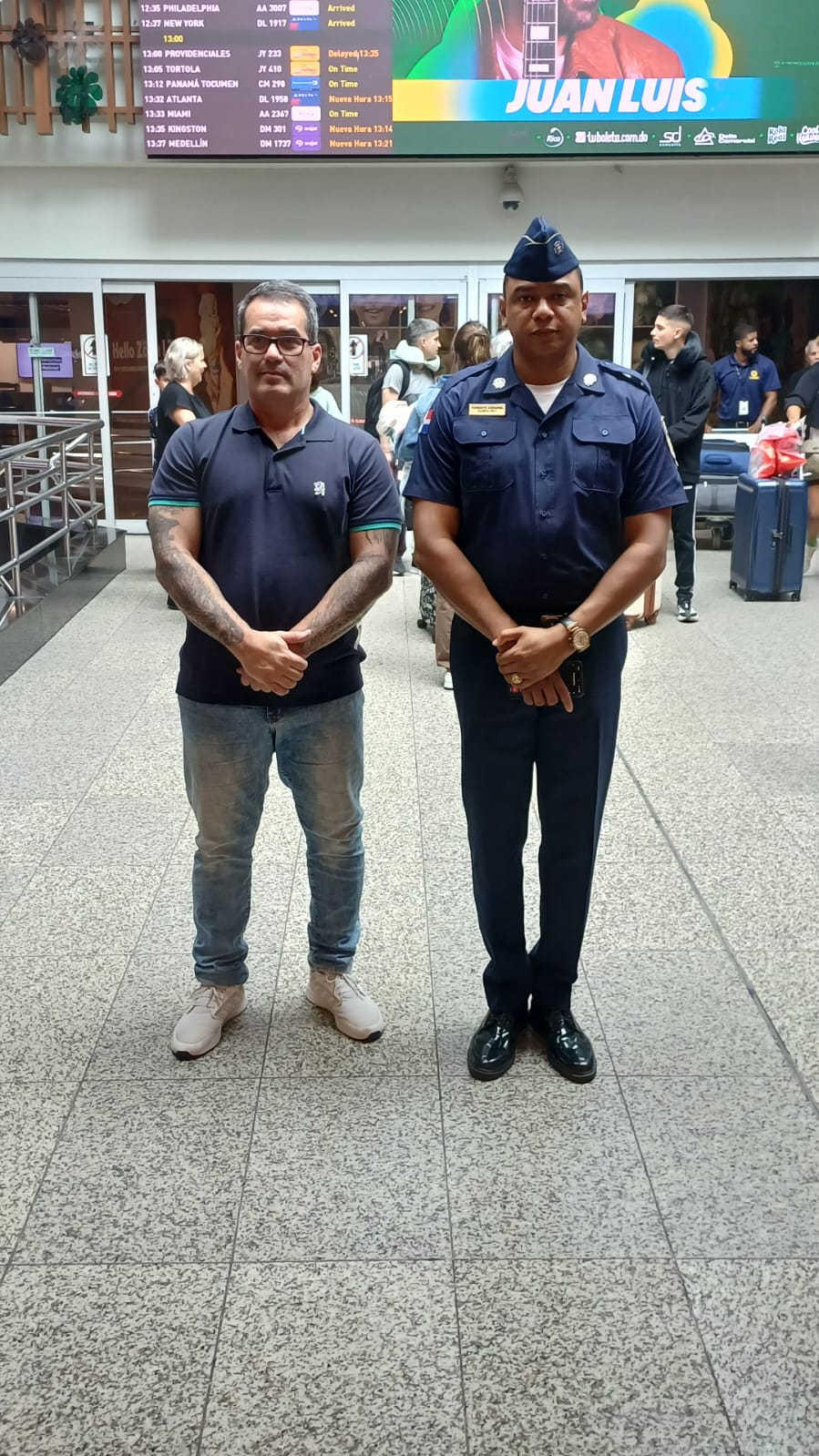 Dos representantes posan en una terminal aeroportuaria.