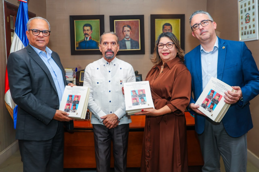 Representantes de Efemérides Patrias y UNAPEC posan con ejemplares del libro Ajusticiamiento de Trujillo.