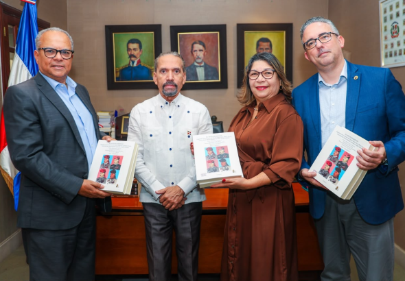 Representantes de Efemérides Patrias y UNAPEC posan con ejemplares del libro Ajusticiamiento de Trujillo.