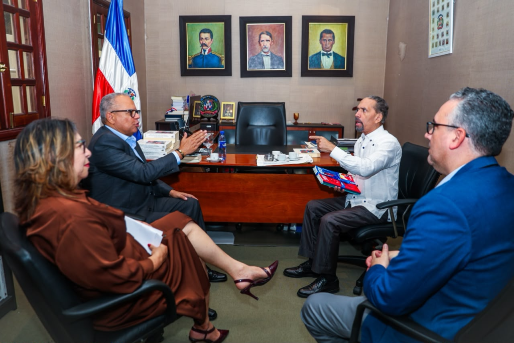 Representantes de Efemérides Patrias y UNAPEC conversan durante una reunión institucional.