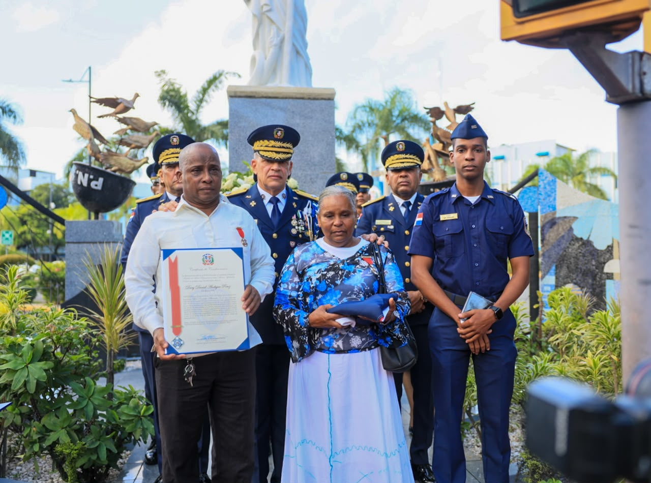Familiares con una bandera y un reconocimiento durante el homenaje
