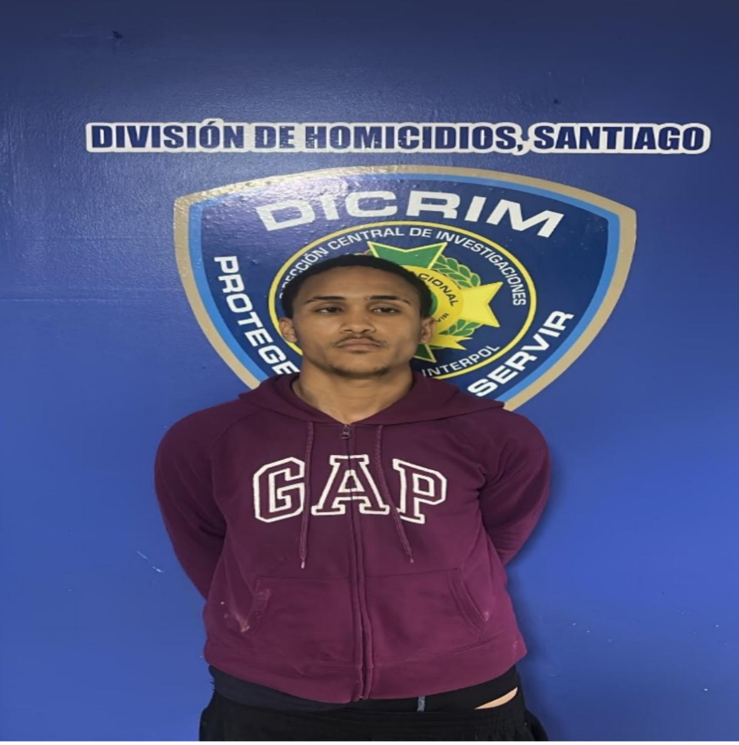 Persona fotografiada ante el emblema de la División de Homicidios de Santiago