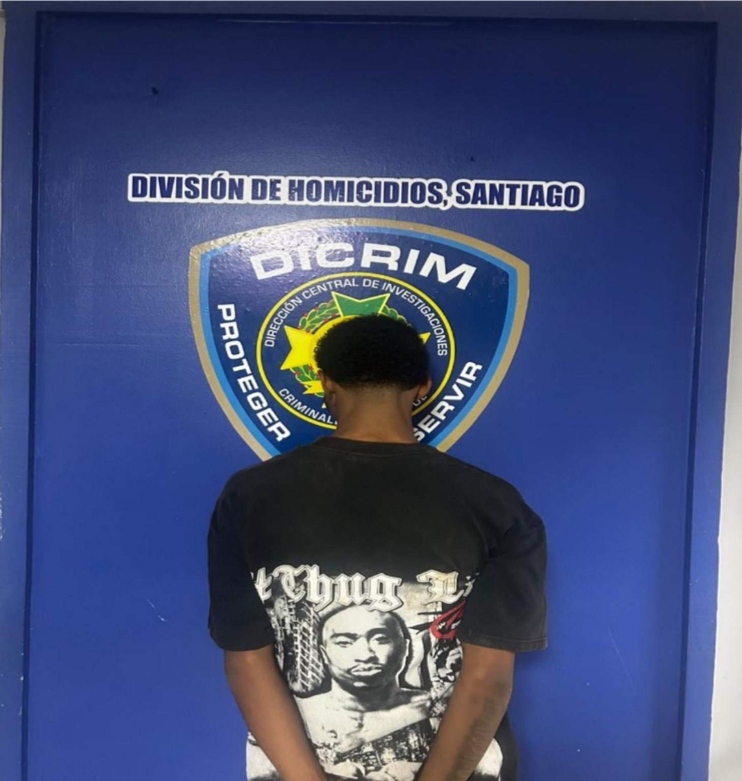 Persona de espaldas ante el emblema de la División de Homicidios de Santiago