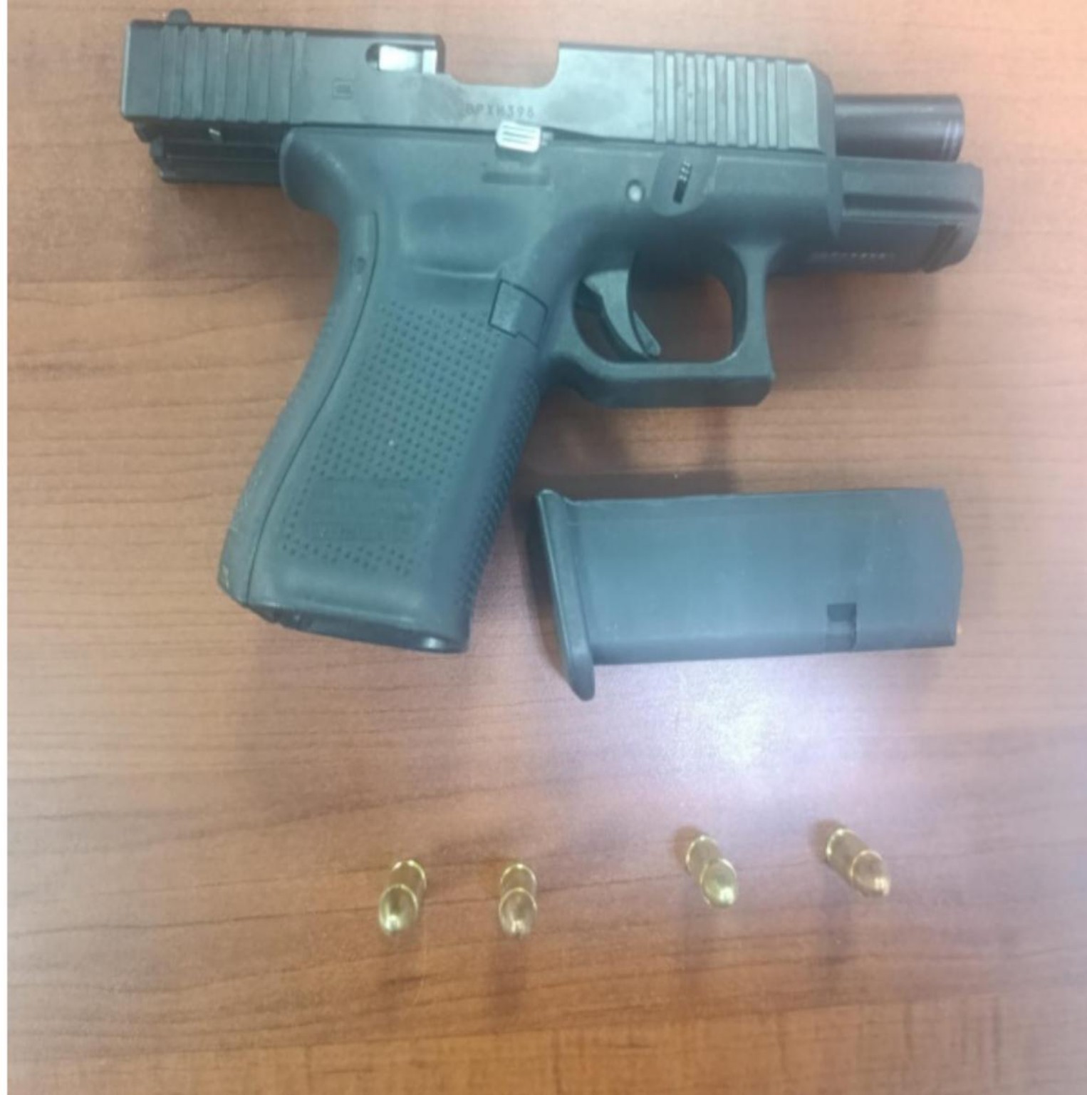 Pistola, cargador y cuatro cartuchos sobre una mesa